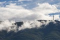 A peak on Vitosha mountain in Bulgaria surrounded by white clouds like mist. Blue sky with clouds. Beautiful landscape. Royalty Free Stock Photo