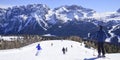 The peaks of the Alps mountains covered with snow. the ski slopes crowded with skiers on a sunny winter day