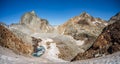 Peaks Gourgs Blancs and Gourdon in symmetry over small blue frozen lake and snow tongue