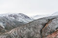 Peaks of red mountains are covered with snow, winter highlands landscape