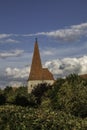 Peaky city wall tower with trees and the blue cloudy sky Royalty Free Stock Photo