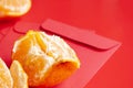 Peal Mandarin oranges on top of Chinese New Year red packet. Chinese New Year celebration concept Royalty Free Stock Photo