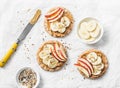 Peanut butter, apple, banana, flax and chia seed crackers toast on a light background Royalty Free Stock Photo