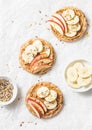 Peanut butter, apple, banana, flax and chia seed crackers toast on a light background