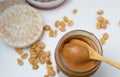 Peanut butter with bamboo spoon decorated with roasted peanuts on white table. Royalty Free Stock Photo