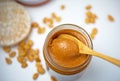 Peanut butter with bamboo spoon decorated with roasted peanuts on white table. Royalty Free Stock Photo