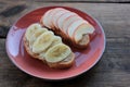 Peanut butter banana and apple sandwiches on wooden background. Slice of bread with peanut paste and fresh fruits on cutting board Royalty Free Stock Photo