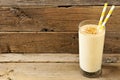 Peanut-butter banana oat smoothie with straws over rustic wood Royalty Free Stock Photo