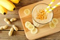 Peanut-butter banana oat smoothie with straws, on wood Royalty Free Stock Photo