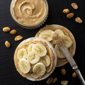 Peanut butter and banana on rice cakes, healthy, dietary food. Black background Royalty Free Stock Photo