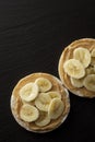 Peanut butter and banana on rice cakes, healthy, dietary food. Black background Royalty Free Stock Photo