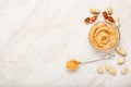 Peanut butter in glass plate with peanuts in shell, peeled peanuts, vintage spoon with peanut butter. Creamy peanut paste flat lay