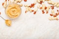 Peanut butter in glass plate with peanuts in shell, peeled peanuts, spoon with peanut butter. Creamy peanut paste flat lay with Royalty Free Stock Photo