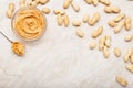 Peanut butter in glass plate with peanuts in shell, spoon with peanut butter. Creamy peanut paste flat lay with place for text on