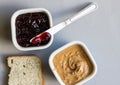 Peanut butter and jelly in bowls with knife and slice of bread o Royalty Free Stock Photo