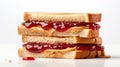 Peanut butter and jelly sandwiches stacked on white background