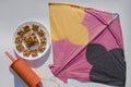 Peanut chikki or Moongfalli chikky bars with Kite and spool string with white background. Makar sankranti, uttarayan, pongal,