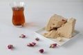 Peanut halva with rose buds and tea in a glass