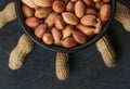 Peanut in nutshell in brown bowl on wooden background. Composition of peanuts Royalty Free Stock Photo