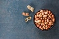 Peanut in nutshell in brown bowl on wooden background. Composition of peanuts Royalty Free Stock Photo