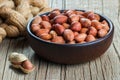 Peanut in nutshell in burlap sack or sackcloth and bowl on wooden background. Composition of peanuts Royalty Free Stock Photo