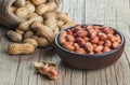 Peanut in nutshell in burlap sack or sackcloth and bowl on wooden background. Composition of peanuts Royalty Free Stock Photo