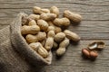 Peanut in nutshell in burlap sack or sackcloth on wooden background. Composition of peanuts Royalty Free Stock Photo