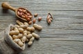 Peanut in nutshell in burlap sack or sackcloth on wooden background. Composition of peanuts Royalty Free Stock Photo