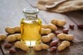 Peanut oil in glass bottle and peanuts on wooden table Royalty Free Stock Photo
