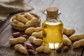 Peanut oil in glass bottle and peanuts on wooden table Royalty Free Stock Photo