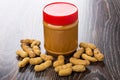 Peanut paste in closed plastic jar, fried peanuts in shell Royalty Free Stock Photo