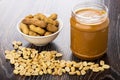 Peanut paste in jar, bowl with nuts, fried peanuts Royalty Free Stock Photo