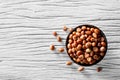 Peanuts bake salt in a small cup, placed on a beautifully patterned wooden floor