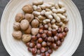 Peanuts, Hazelnuts and Walnuts with Nutshells Mix in Natural Bamboo Plate on Black Stone Background Surface Royalty Free Stock Photo