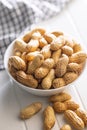 Peanuts in shell. Groundnuts in bowl on white table Royalty Free Stock Photo