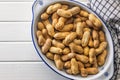 Peanuts in shell. Groundnuts in bowl on white table. Top view Royalty Free Stock Photo