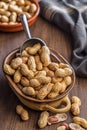 Peanuts in shell. Groundnuts in bowl on wooden table Royalty Free Stock Photo