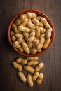 Peanuts in shell. Groundnuts in bowl on wooden table. Top view Royalty Free Stock Photo