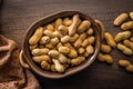 Peanuts in shell. Groundnuts in bowl on wooden table. Top view Royalty Free Stock Photo