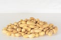 Peanuts. Small pile of peanuts on the white table and gray background. Peanut macro close up Royalty Free Stock Photo