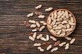 Peanuts on textured wooden background, top view.