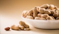 Peanuts. Unshelled nuts in a bowl close up. Roasted pile of peanuts in shell over beige background Royalty Free Stock Photo