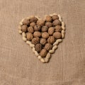 Peanuts and walnuts arranged to form a heart. Royalty Free Stock Photo