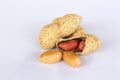 Peanuts  on white background . Two kernels are already unpacked. One of the peanuts, which was removed, revealed a red Royalty Free Stock Photo
