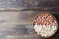 Peanuts on wooden background. Unpeeled, peeled and salted peanuts