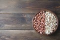 Peanuts on wooden background. Unpeeled, peeled and salted peanuts