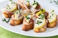 Pear and prosciutto crostini appetizers topped with honey and thyme sprigs, ready for sharing.