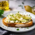Pear toast. Bruschetta with pear, honey, walnut and cottage cheese served on a white plate on a light grey background. Pear and Royalty Free Stock Photo