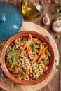 Pearl barley grain porridge with carrot, mushrooms, green peas and onion