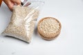 Pearl barley grains in a wooden bowl and a transparent bag on a white background Royalty Free Stock Photo